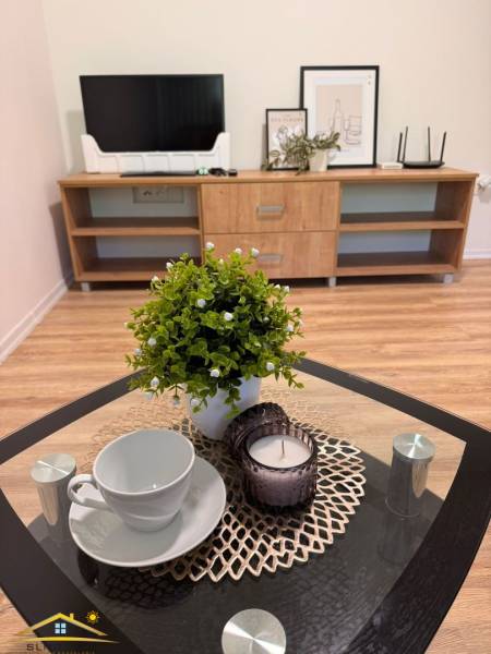 V 1-pokojovém bytě je konferenční stolek s dekorací, šálkem a svíčkou.