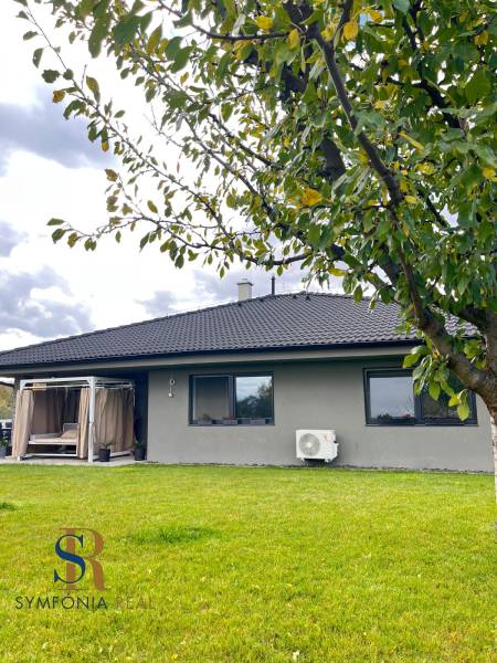 Rodinný dům na Lipové ulici v Dubové, strom a zelený trávník v popředí.