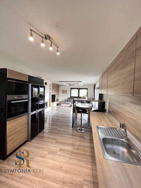 Kuchyně v rodinném domě s podlahou s dřevěným dekorem a praktickým sezením.