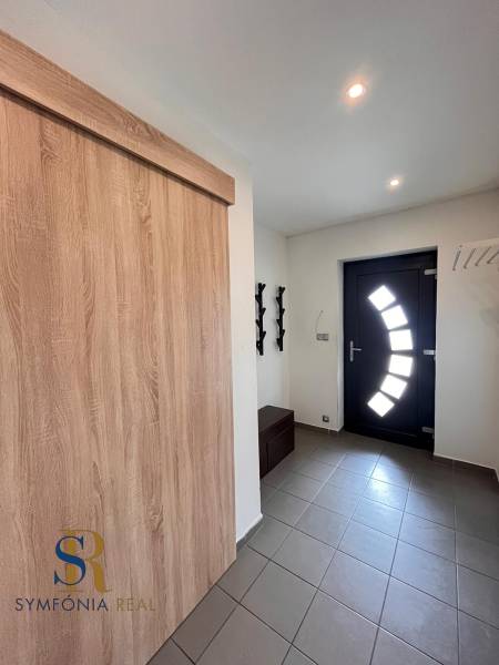 Vstupní chodba v rodinném domě s dlažbou a moderními dveřmi.