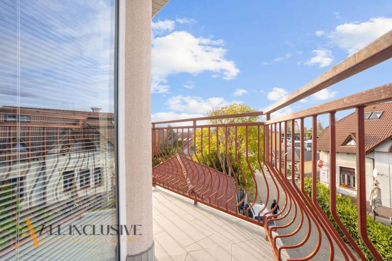 Výhled z balkonu na střechy a stromy v 2-pokojovém bytě na Kukučínově v Dunajské Stredě.