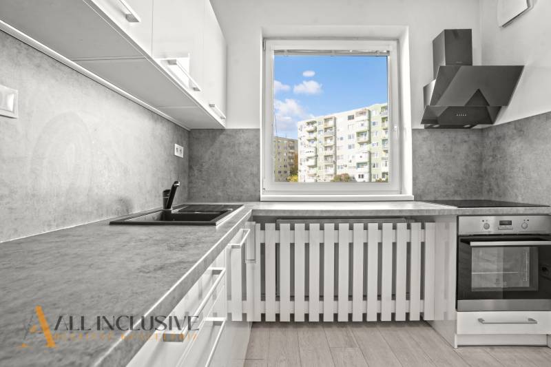 Kuchyně v 2pokojovém bytě s výhledem a podlahou s dřevěným dekorem.