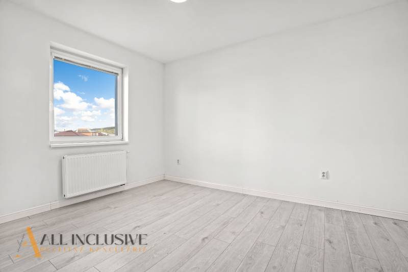 Pokoj v 2-pokojovém bytě s oknem a podlahou s dřevěným dekorem.