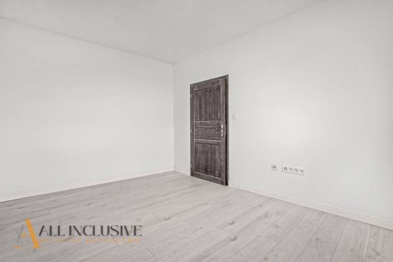 Interiér 2-pokojového bytu s bílými stěnami a podlahou s dřevěným dekorem.