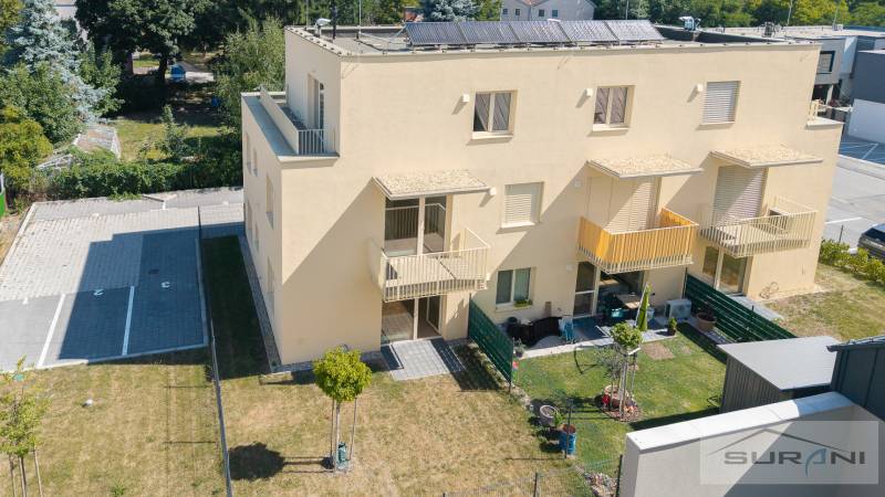 Žlutý bytový dům na Železniční ulici v Bratislavě-Vrakuni se zahradou a parkovacími místy.