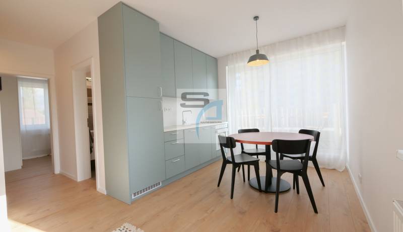 Jídelní kout se stolem a židlemi, vestavěnými skříňkami a podlahou s dřevěným dekorem.