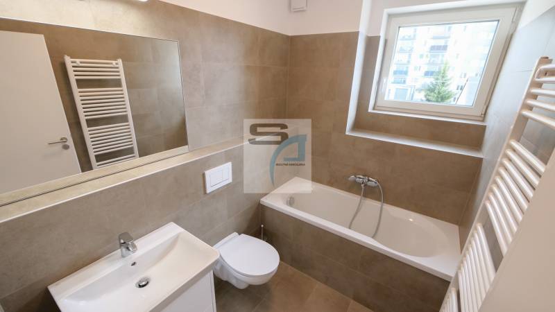 Koupelna v 2-pokojovém bytě s vanou, umyvadlem, zrcadlem a oknem.