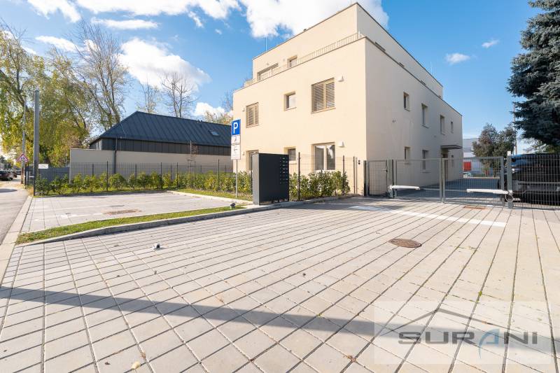 Exteriér budovy na Železniční ulici v Bratislavě - Vrakuni, s parkováním a zelení.