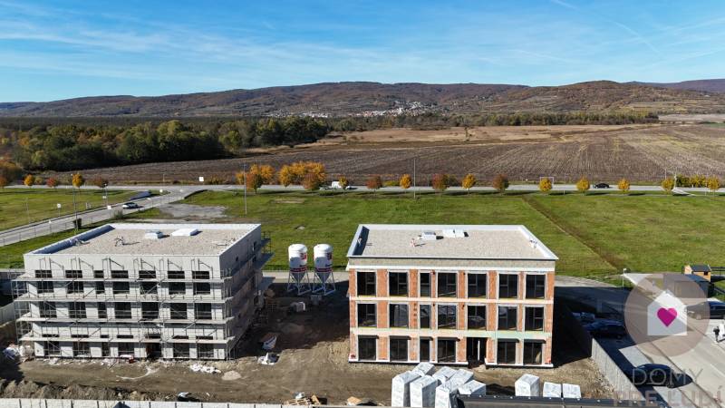 Stavební projekt na Duhové ulici ve Slovenském Grobu, obklopený přírodou a otevřenou krajinou.