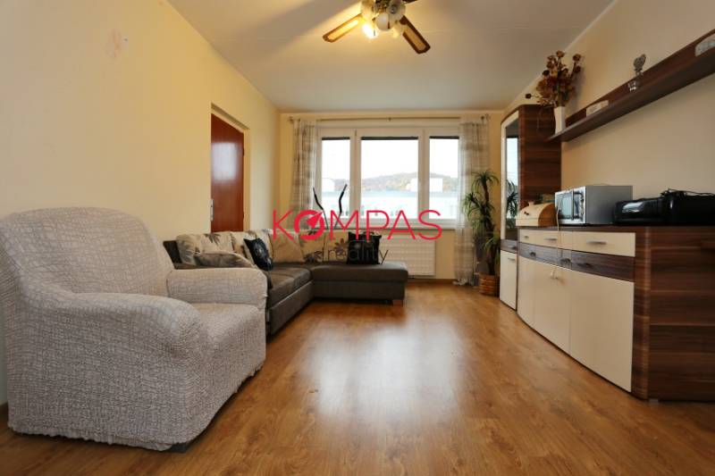 Obývací pokoj s pohovkou a skříňkami, podlaha s dřevěným dekorem, 3-pokojový byt.