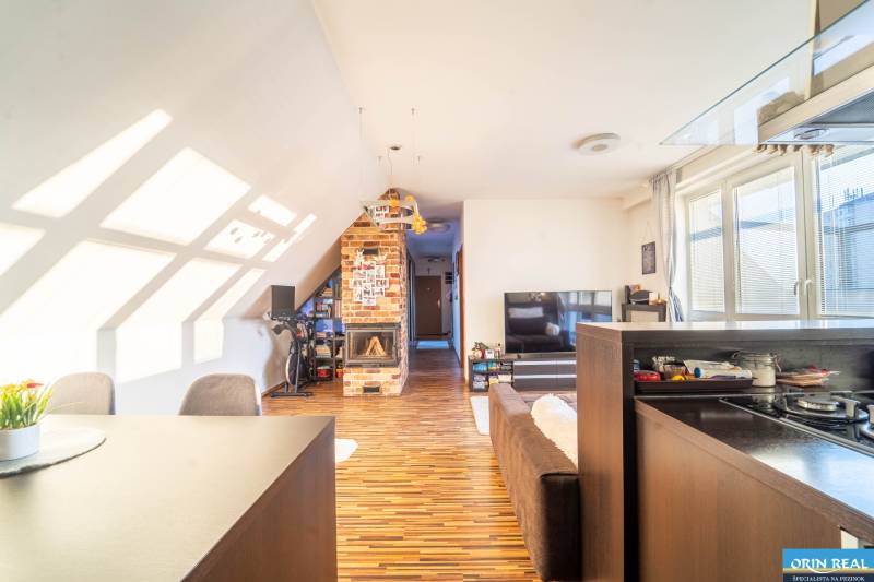 Obývací pokoj v 2-pokojovém bytě s podlahou s dřevěným dekorem a cihlovým krbem.