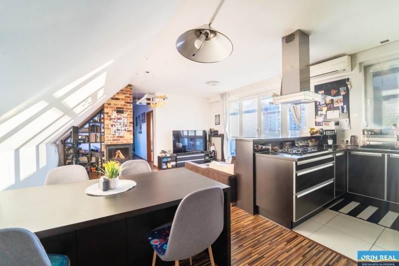 Kuchyně s televizorem, krbem a podlahou s dřevěným dekorem v 2-pokojovém bytě.