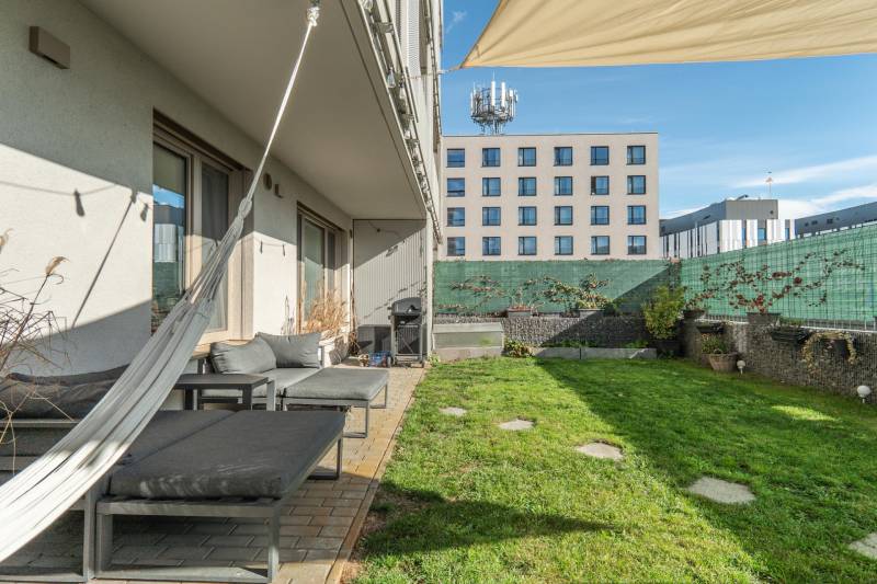 Zahradní terasa u 3pokojového bytu v Bratislavě - Lamači, Jána Langoše, s trávníkem a závěsy.