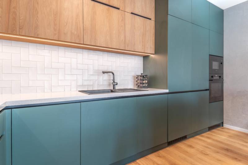 Kuchyně s tyrkysovými skříňkami, dřevěným dekorem a bílými obkladačkami, 3pokojový byt.