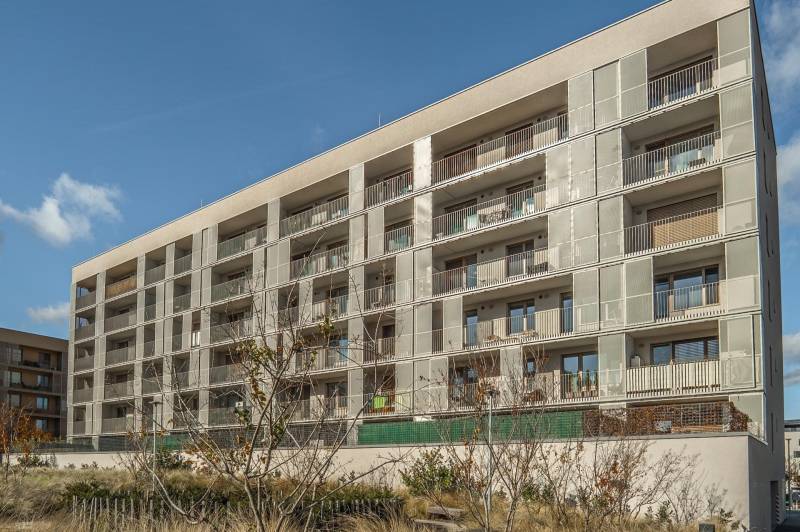 Bytový dům s balkony v Bratislavě na Lamači na Jána Langoša, obklopený zelení.