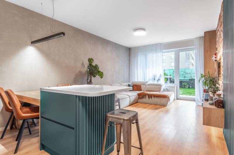 Obývací pokoj ve 3-pokojovém bytě s pohodlnou sedačkou a podlahou s dřevěným dekorem.