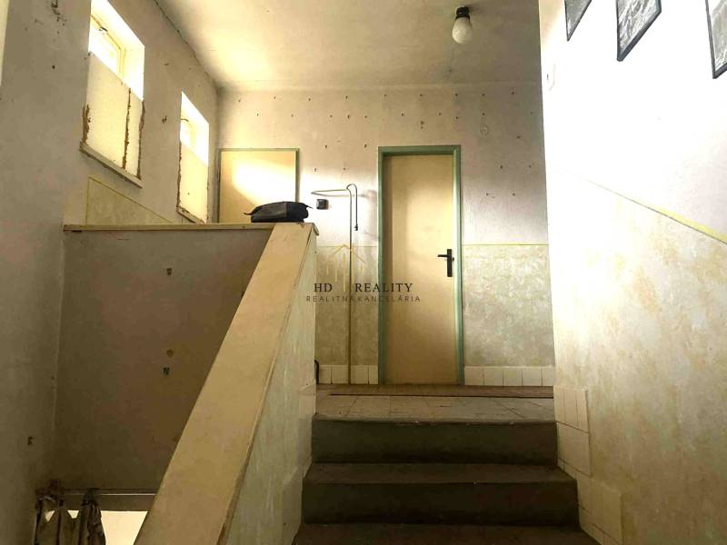 Jednoduché schodiště v rodinném domě s minimalistickým interiérem a světlými stěnami.