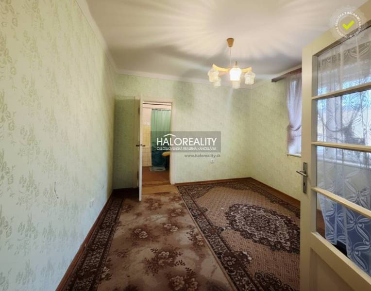 Pokoj v rodinném domě s kobercem, zelenými stěnami a dekorativním osvětlením.