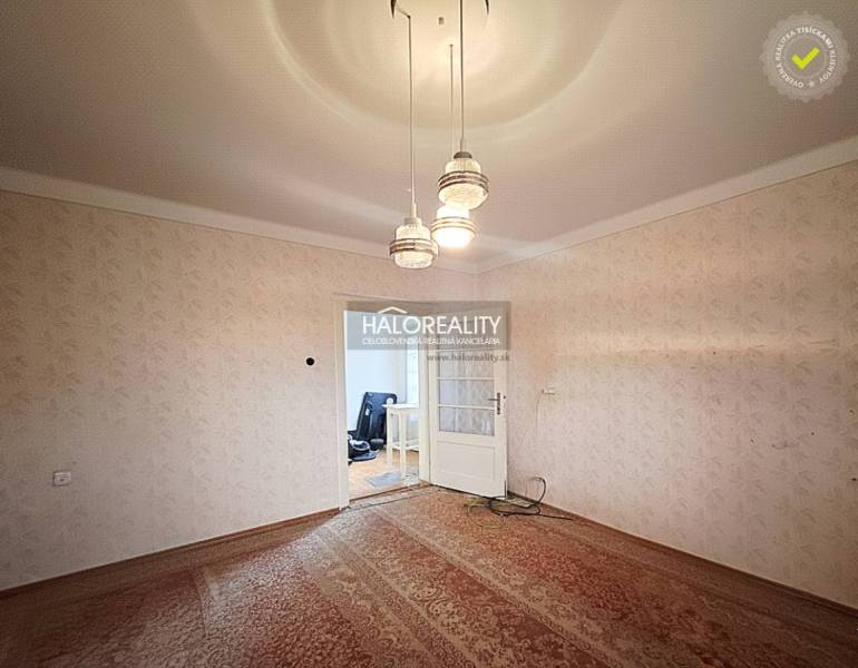 Pokoj v rodinném domě s kobercovou podlahou a závěsným osvětlením.