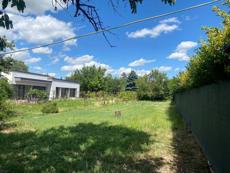 Zahrada s trávníkem a moderní budovou v lokalitě Bratislava - Podunajské Biskupice, Podunajské Biskupice, Pozemky - bydlení.