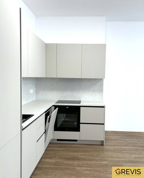 Kuchyně ve 4-pokojovém bytě s podlahou s dřevěným dekorem a bílými skříňkami.