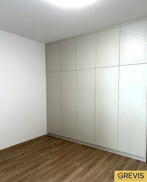 Ve 4-pokojovém bytě je vestavěná skříň a podlaha s dřevěným dekorem.