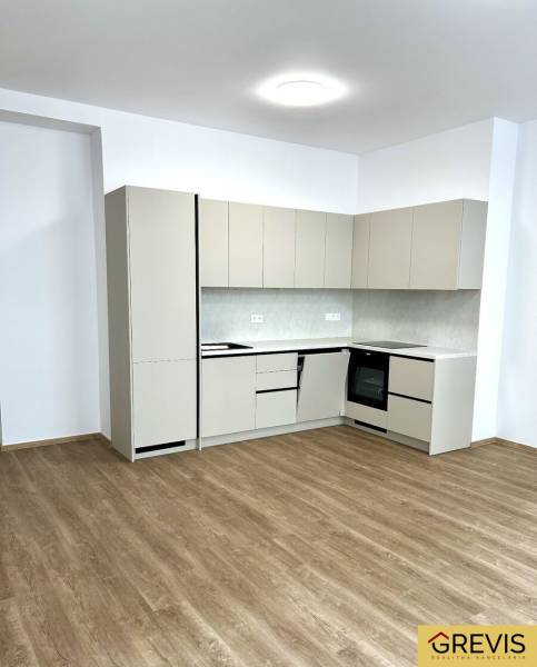 Kuchyně ve 4-pokojovém bytě s podlahou s dřevěným dekorem a světlou linkou.