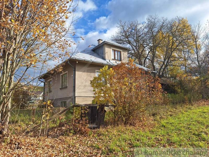 Rodinný dům v Liptovských Beharovcích uprostřed barevných podzimních stromů a keřů.