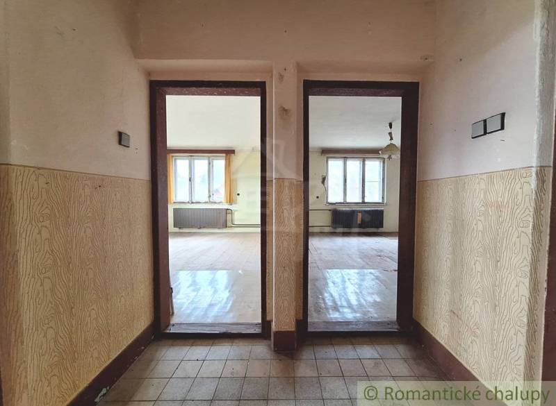 Interiér rodinného domu s podlahou s dřevěným dekorem a dvěma místnostmi.