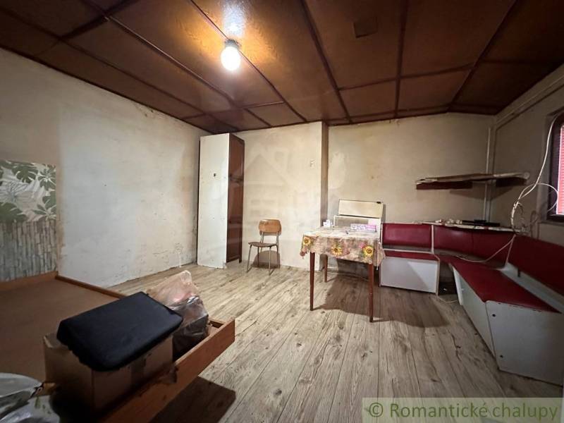 Interiér rodinného domu s lavicí a stolem, podlaha s dřevěným dekorem.