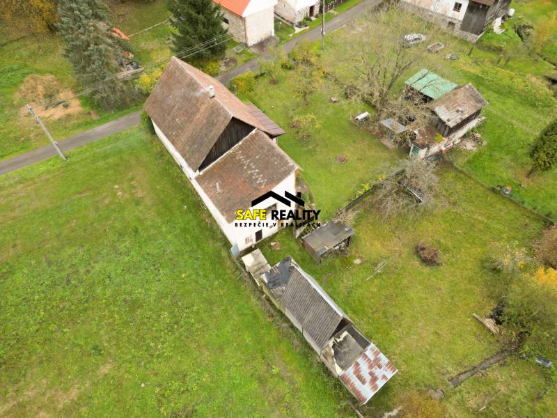 Rodinný dům na Sklené ve Sklené obklopený zahradou, s vedlejšími stavbami a stromy.