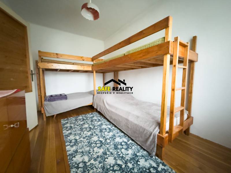 Palanda v rodinném domě s podlahou s dřevěným dekorem a vzorovaným kobercem.