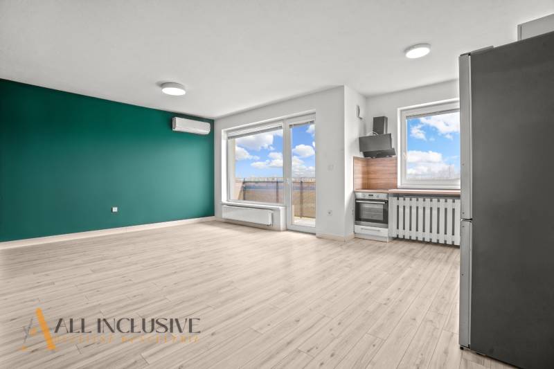 Obývací pokoj s kuchyňským koutem v 2-pokojovém bytě a podlahou s dřevěným dekorem.