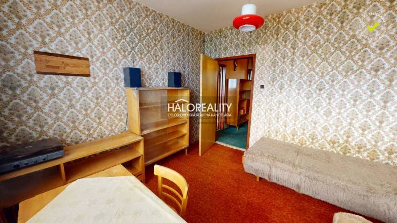 Interiér 3-pokojového bytu s retro tapetami, nábytkem a červenou lampou.