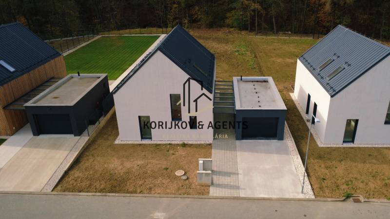 Rodinné domy na ulici Pod Drieňovou v Kamenici nad Cirochou obklopené trávníkem a příjezdovou cestou.