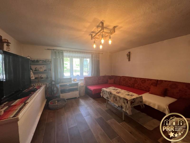 Obývací pokoj a chata s tradičním nábytkem, pohovkou a dřevěnou podlahou pro relaxaci.