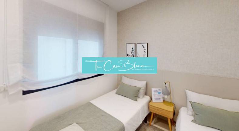 Pokoj v rekreačním apartmánu s dvěma jednolůžky a jemnými dekoracemi na stěně.