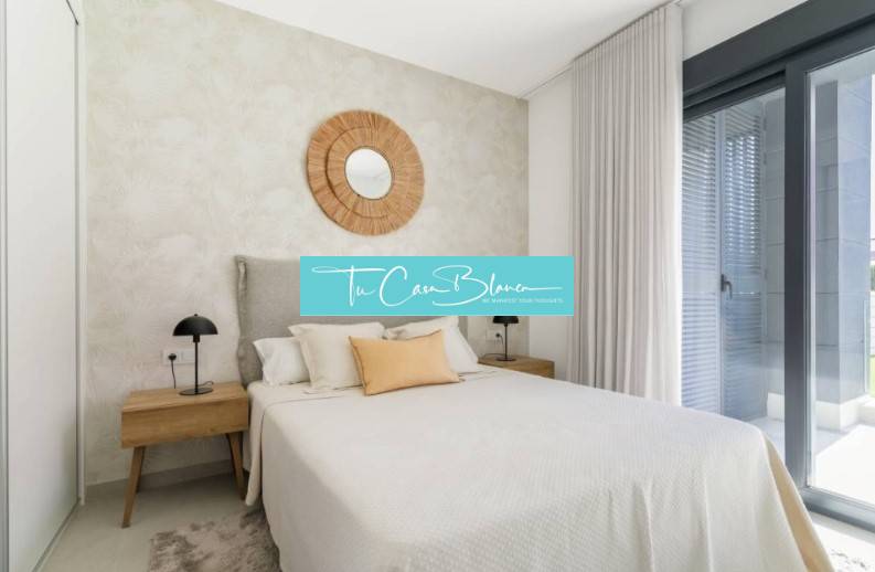 Ložnice v rekreačním apartmánu, postel, noční stolky, velké okno.