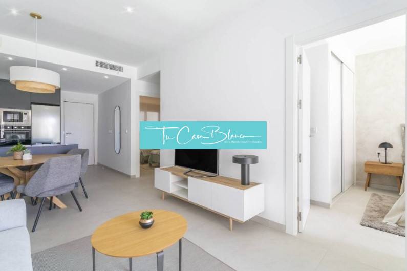 Rekreační apartmán s otevřeným obývacím pokojem, jídelním stolem a podlahou s dřevěným dekorem.