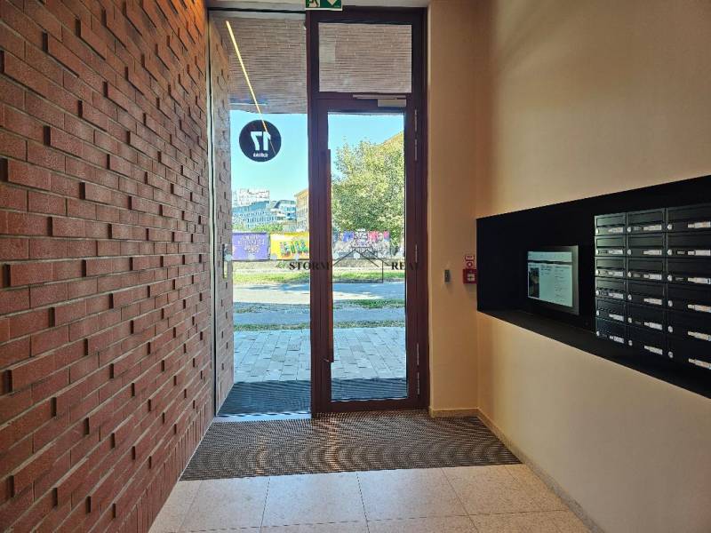 Vstupní hala s poštovními schránkami a cihlovou stěnou na ulici Košická, v Bratislavě - Ružinov.