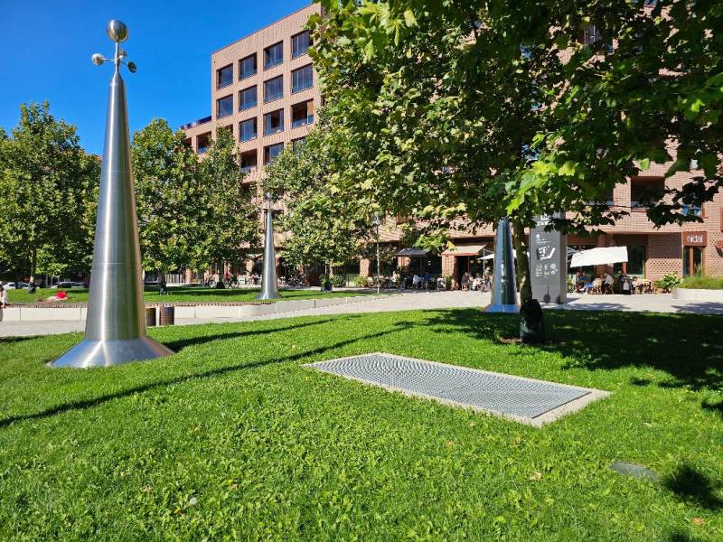 Zeleň a kovové sochy před budovou v Bratislavě - Ružinově na ulici Košická, 3-pokojový byt.