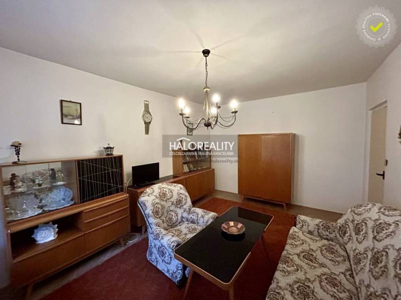 Obývací pokoj se starožitným nábytkem a lustrem ve 4-pokojovém bytě.