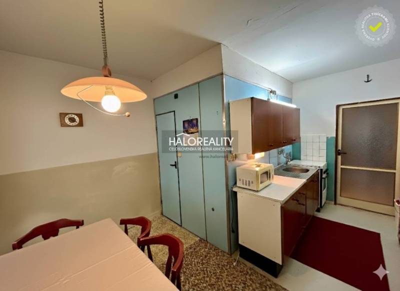 Kuchyně ve 4-pokojovém bytě s jídelním stolem a kuchyňskou linkou.