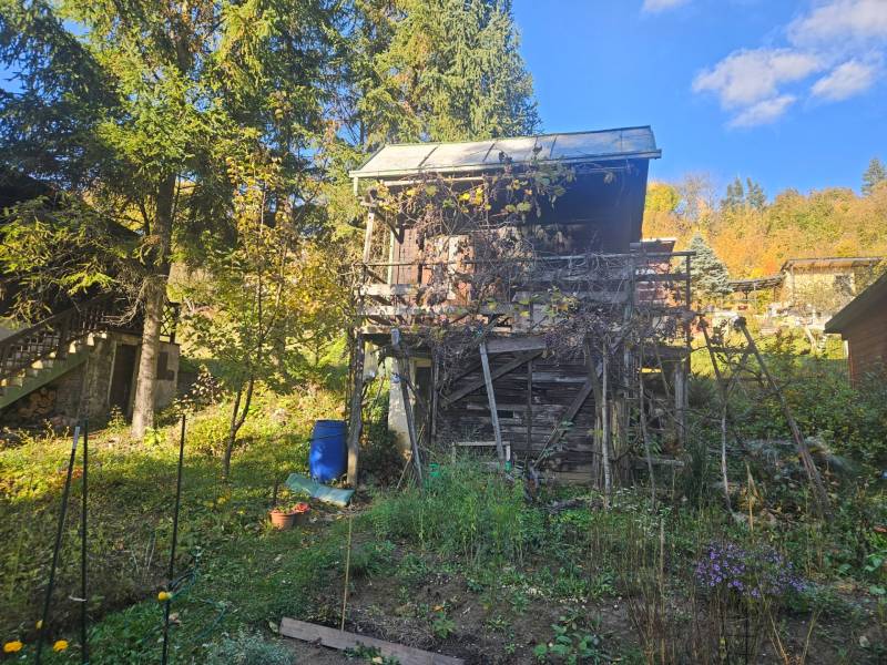 Chata v Sadech pod Dedovcem v Trenčianských Teplicích obklopená zelení a stromy.