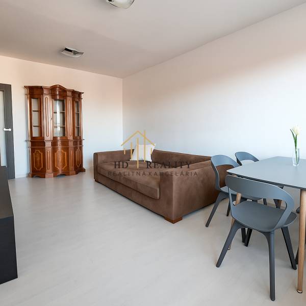 Obývací pokoj s pohovkou a vitrínou, podlaha s dřevěným dekorem ve 3-pokojovém bytě.