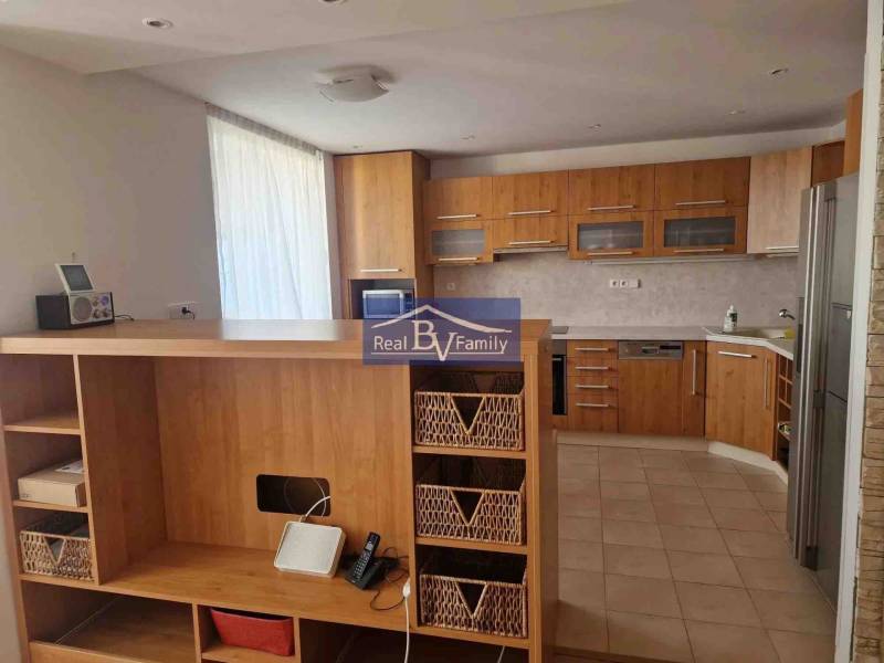 Kuchyňská linka s dřevěným dekorem a úložným prostorem v 2pokojovém bytě.