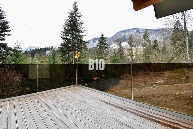 Chata v Terchové s terasou nabízí výhled na zasněžené hory a les.