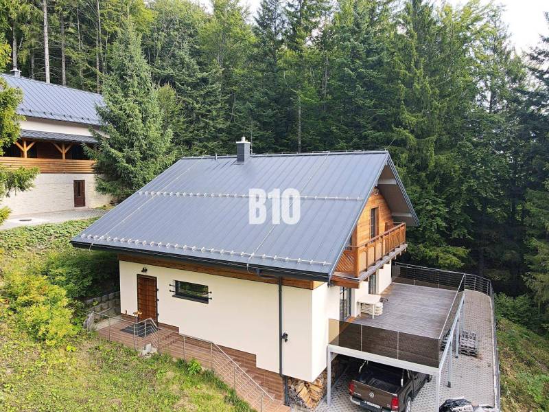 Chata v Terchové obklopená lesy s velkou terasou a parkovacím místem.