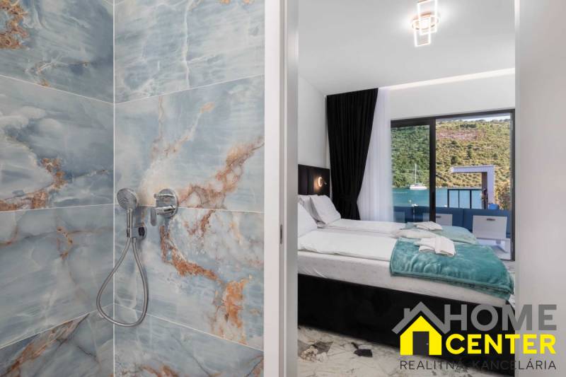 Koupelna s mramorovými obklady a ložnice ve vile s výhledem na moře.