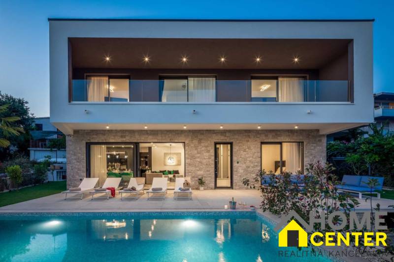 Vila v Bale s bazénem a terasou, obklopená zelení a odpočinkovými prostory.